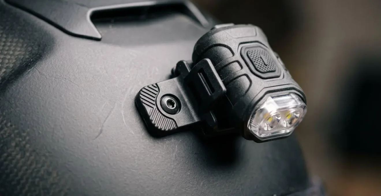 Close-up view of battery-powered LED lights strategically positioned on a rider's helmet and shoulders creating a biomotion visibility pattern