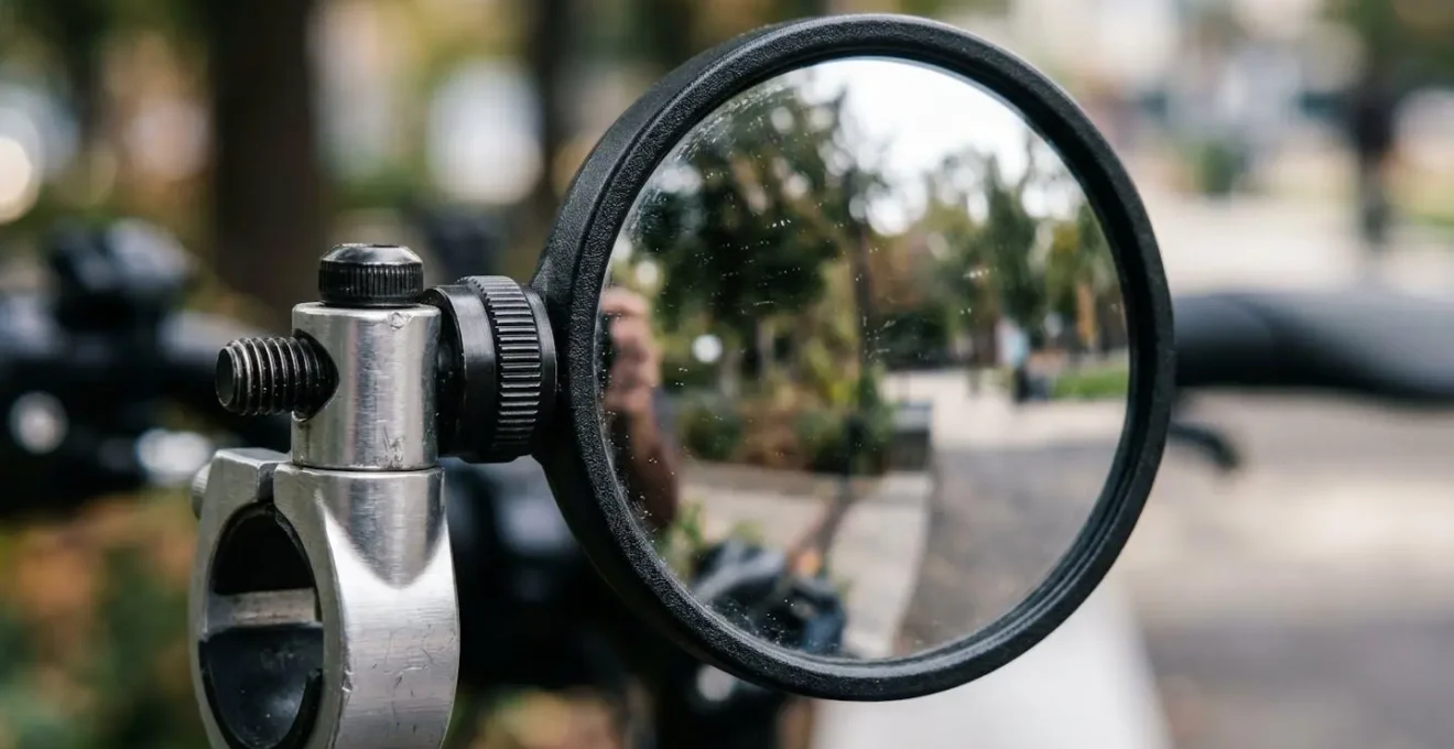 Close-up view of handlebar-mounted mirror showing optimal angle adjustment for zero-movement peripheral vision