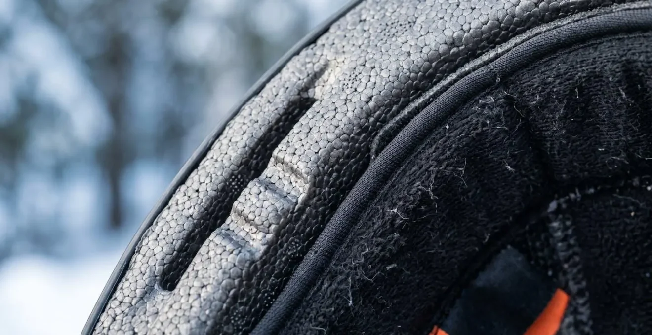 Detailed macro view of snow helmet foam insulation and dual-certification label design for cold-weather scooter safety