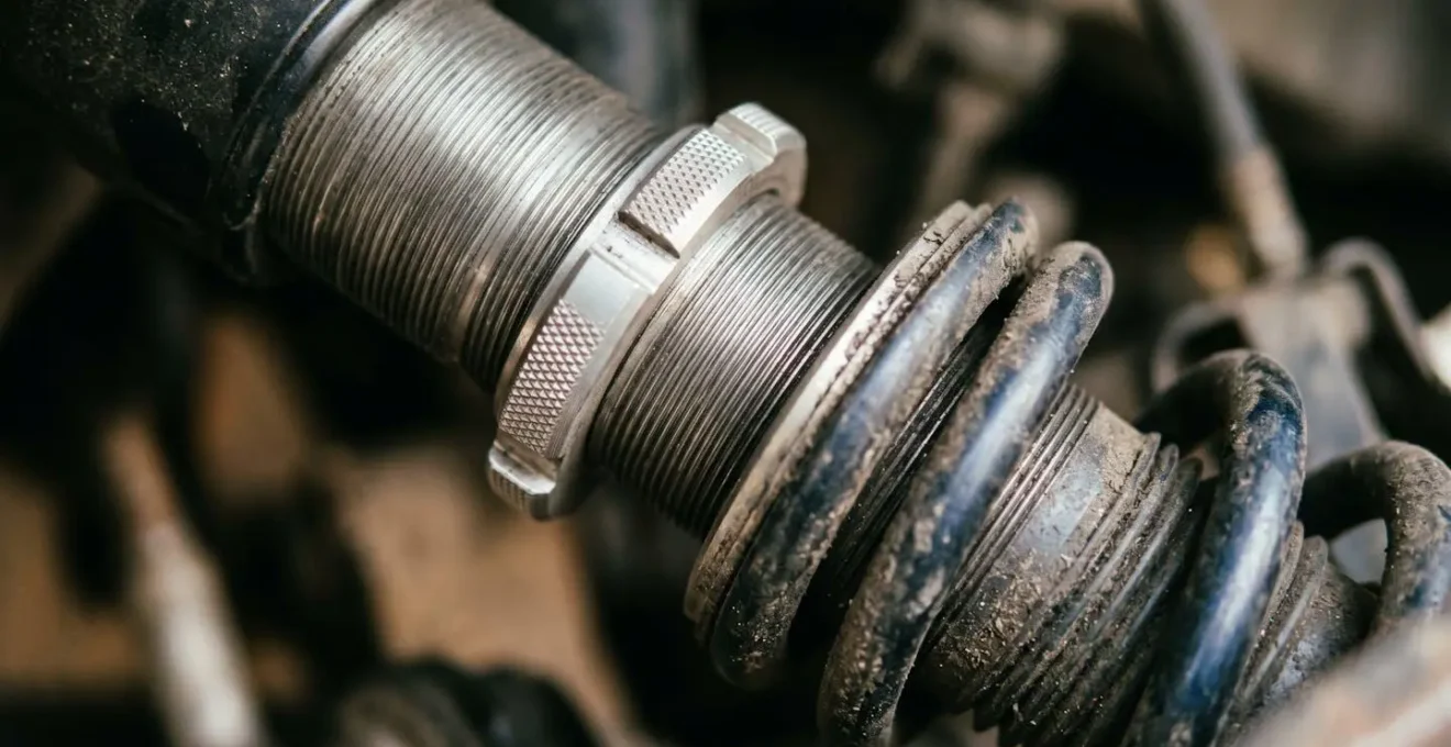 Close-up view of electric scooter suspension spring preload adjustment collar and mechanism