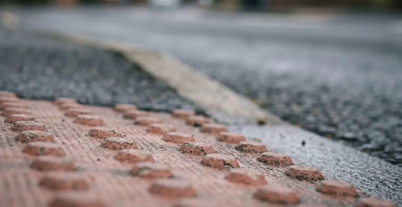 Close-up view of a dropped kerb on a British street showing textured paving