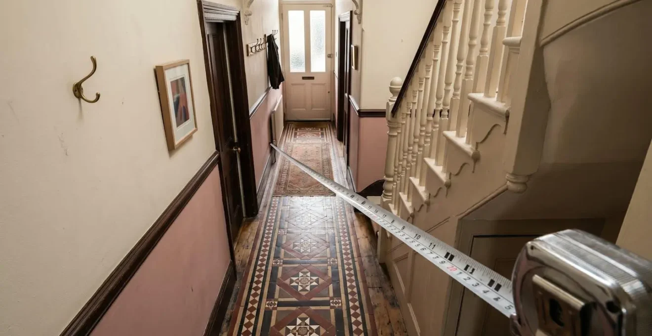 Tape measure extended across a traditional British hallway showing dimensional challenges
